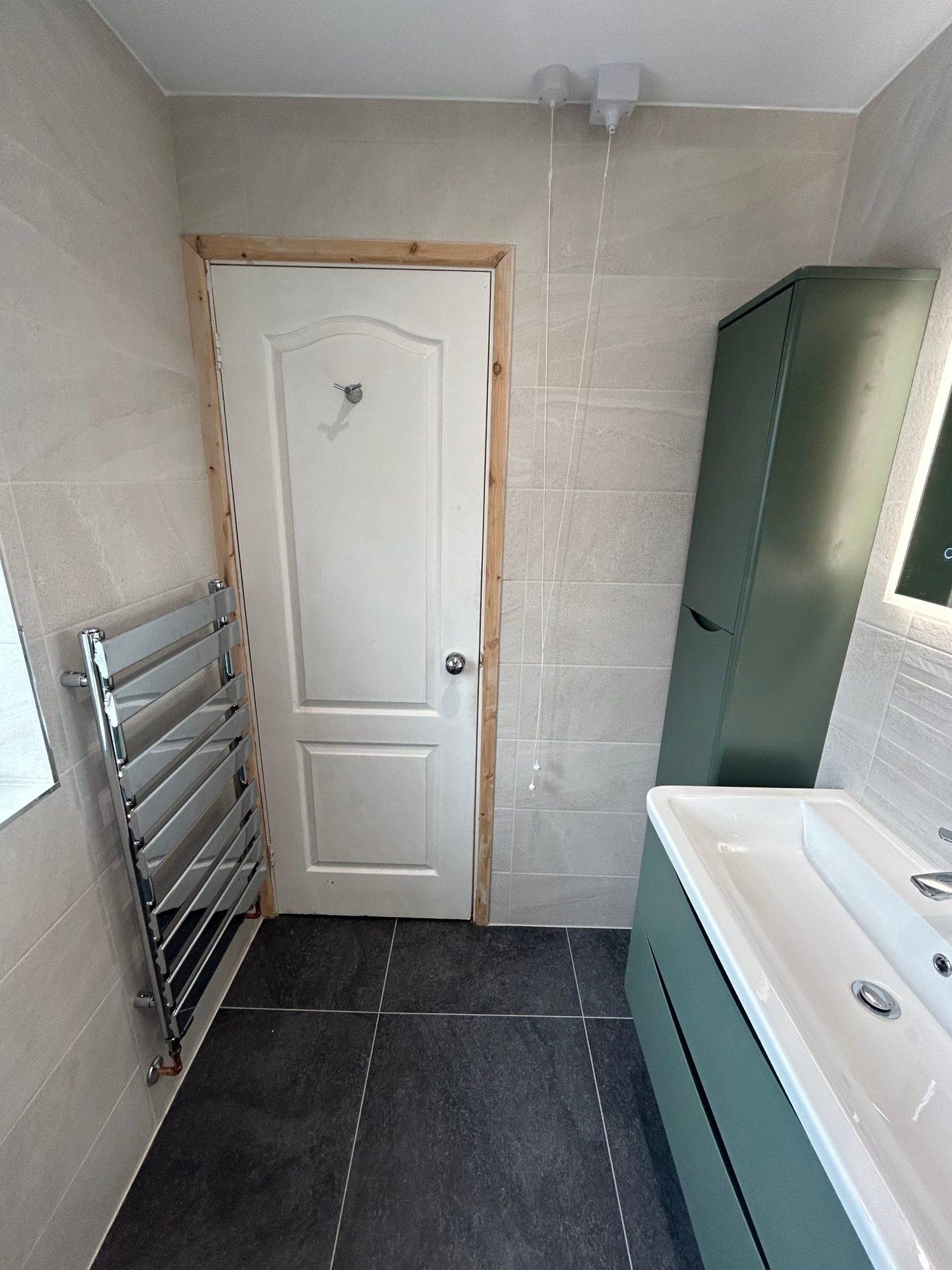 Green tall cabinet, vanity and chrome towel radiator
